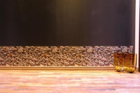 a wall filled with rocks and a vase on the floor at Athens Habitat in Athens