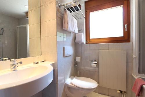 サースフェーにあるホテル イムセンのバスルーム(洗面台、トイレ付)、窓が備わります。