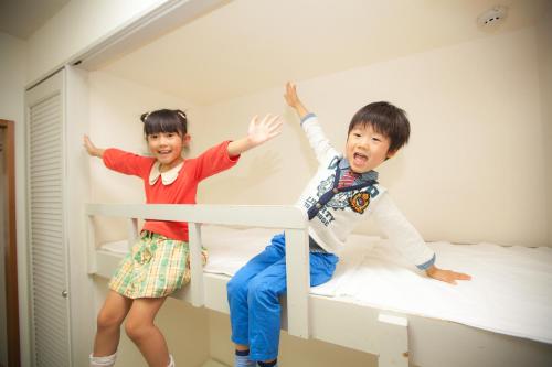 two young children are sitting on a bunk bed at Hotel Angel Grandia Echigo Nakazato in Yuzawa