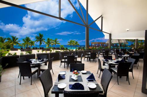 a restaurant with tables and chairs and a view of the ocean at Mana Island Resort & Spa - Fiji in Mana Island