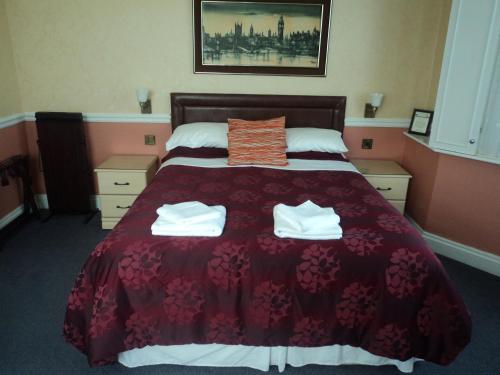 a hotel room with a bed with two towels on it at Arundel Park Hotel in Arundel