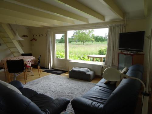 a living room with a couch and a large window at Natuurhuisje Silverhuys in Oosterstreek