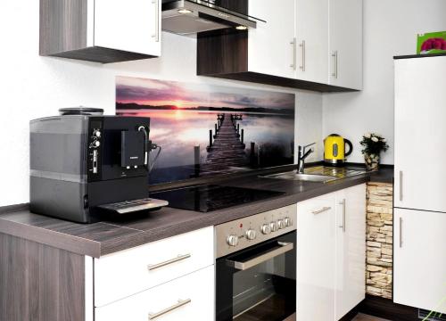 y cocina con microondas y fogones. horno superior en Ferienwohnung Bollenhut, en Schluchsee