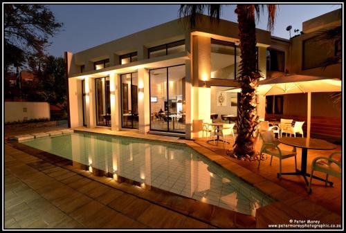 a house with a swimming pool in front of a house at The Lakes Boutique Lodge in Pretoria