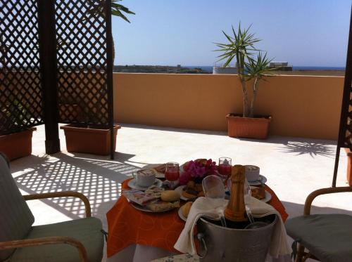 a table with a plate of food on a balcony at Hotel Medusa in Lampedusa