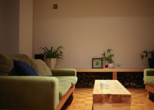 a living room with two couches and a coffee table at Muikamachi Hutte in Minami Uonuma