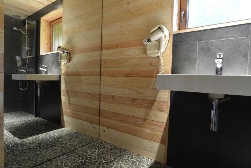 baño con 2 lavabos y pared de madera en Le chalet de Valentine, en Ventron