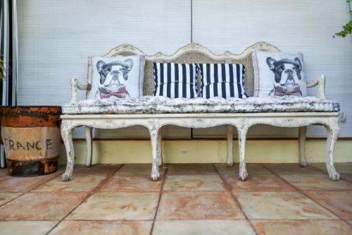 a white bench with pillows of dogs on it at Summerfield Botanical Garden & Exclusive Resort in Matsapha