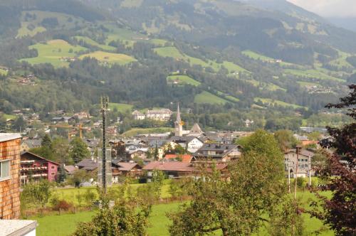 a town in a valley with mountains in the background at Frühstückspension & Appartements Eugenie in Kitzbühel