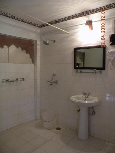 a bathroom with a sink and a toilet and a mirror at Bhanwar Vilas Palace in Karauli
