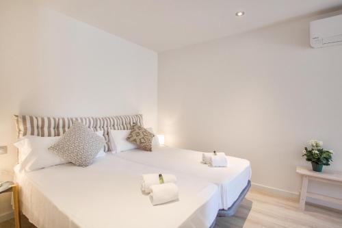 a bedroom with two beds with white sheets and pillows at Flateli- Plaça Catalunya 2-1 in Girona