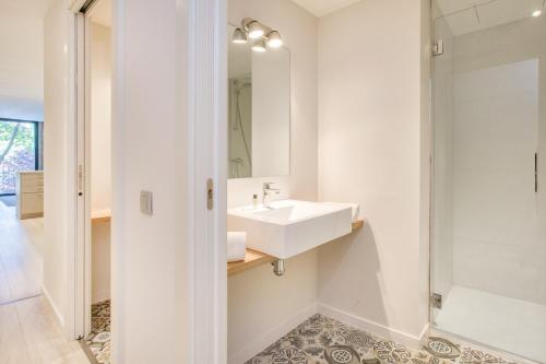 y baño blanco con lavabo y ducha. en Flateli- Plaça Catalunya 2-1, en Girona