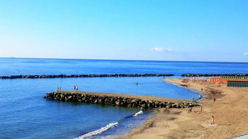 a group of people standing on a pier in the water at Albergo Belsoggiorno in Sanremo
