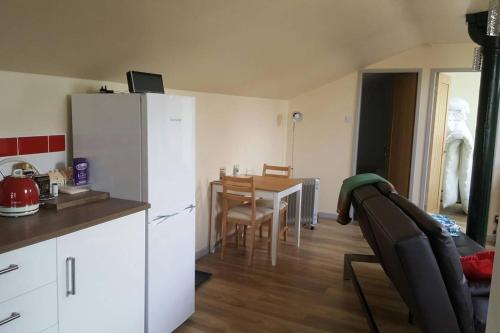 a kitchen with a table and a white refrigerator at Stone Eater in Marsden