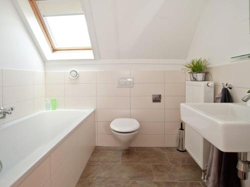 a bathroom with a tub and a toilet and a sink at Tail-Wagging Lake Escape in Heel