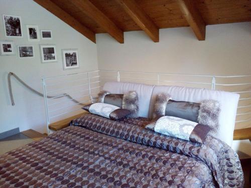 una camera con un letto con due cuscini sopra di Relais Profumo di Vino a Borgomanero