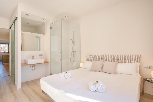 a bedroom with a white bed with two towels on it at Flateli - Exclusivo Plaça Catalunya 4-1 in Girona