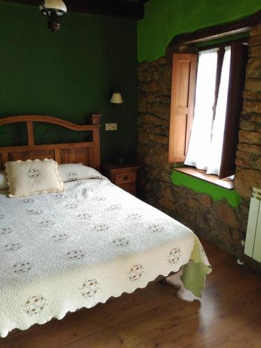 a bedroom with a wooden bed and a window at Casa De Aldea Fonfria in Las Vegas De Cardeo