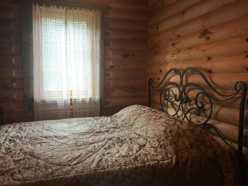a bed in a log cabin with a window at Meresihi talu in Vainupea