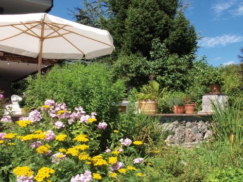 a garden with an umbrella and flowers at Haus Bernhardt-Fromm in St. Blasien