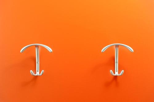 two metal hooks on an orange background at Hotel Mediterraneo in Sottomarina