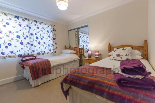 a bedroom with two beds and a window at Edgehill B&B in Kirkhill of Kennethmont