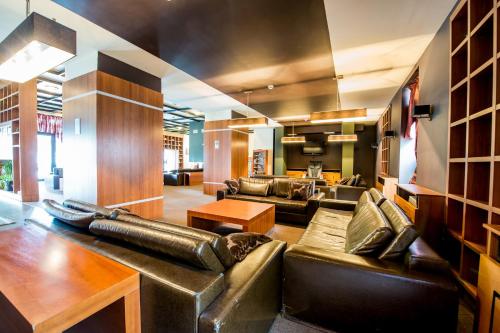 a large living room with leather couches and tables at Snezhanka Hotel Pamporovo-All inclusive & Half Board in Pamporovo