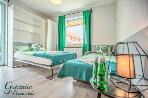 プシビツにあるGościniec Przywidzkiの緑のカーテンが備わる客室のベッド2台