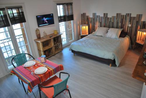a bedroom with a bed and a table and chairs at cal erre in Céret
