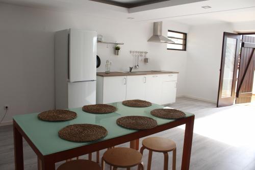 a kitchen with a table with four chairs and a refrigerator at Surf Loft Open Space in Ericeira