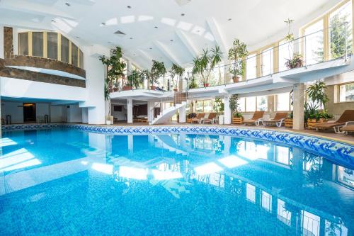 a large pool in a building with blue water at Snezhanka Hotel Pamporovo - All inclusive in Pamporovo