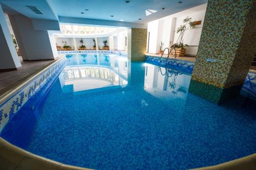 a large pool with blue water in a hotel at Snezhanka Hotel Pamporovo-All inclusive & Half Board in Pamporovo