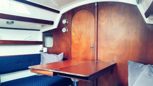 ein kleines Zimmer mit einem Holztisch auf einem Zug in der Unterkunft City Sailing in Amsterdam