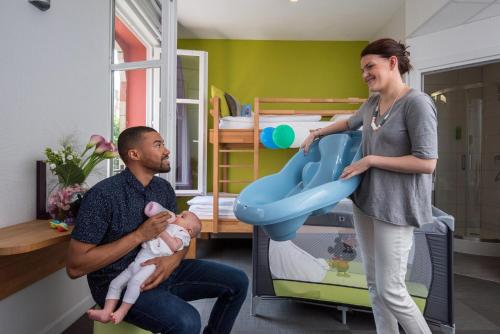 a man and a woman holding a baby in a room at Ciarus in Strasbourg
