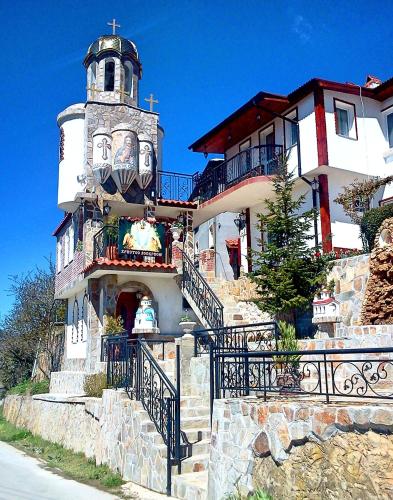 ein Gebäude mit einem Uhrturm darüber in der Unterkunft Kashtata s Paraklisa in Borowo