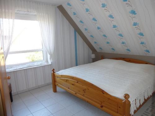 ein Schlafzimmer mit einem Holzbett mit blauen Blumen an der Wand in der Unterkunft Appartement Stader Str. 3 in Cuxhaven