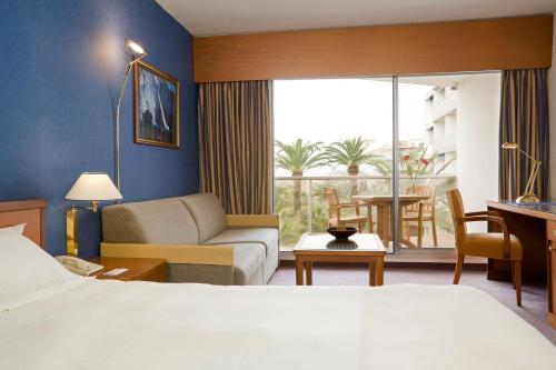 a hotel room with a bed and a living room at Hotel Cannes Montfleury in Cannes