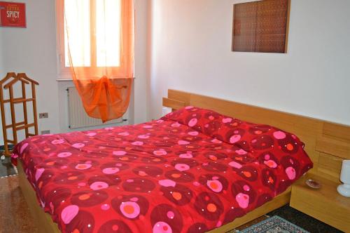 ジェノヴァにあるHouse Orione by Holiday Worldのベッド(ピンクの花が飾られた赤い掛け布団付)