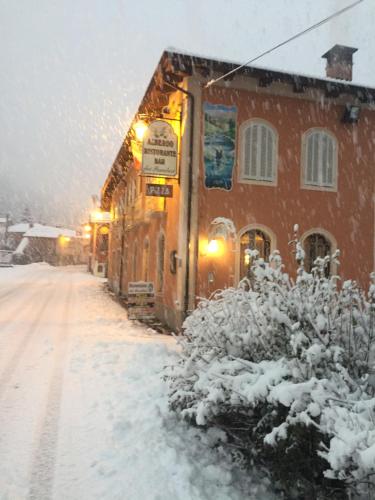 a snow covered street in front of a building at Albergo dei Pescatori in Chiusa di Pesio