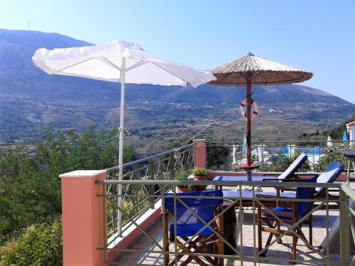 a patio with a table and an umbrella and chairs at Villa Alexandros in Zóla