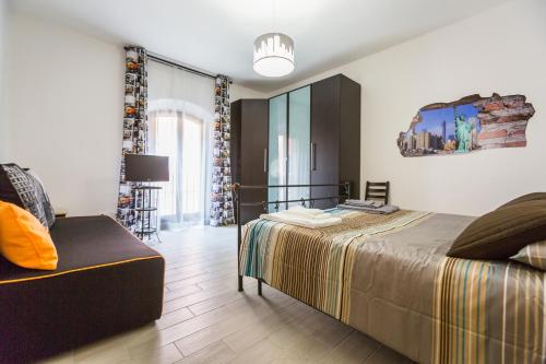 ボローニャにあるBologna Butterfly Apartmentのベッドルーム1室(ベッド1台、ソファ付)