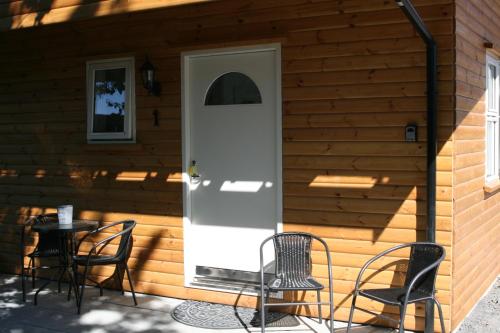 a front door of a house with chairs and a table at Country Dream - Langholt 2 in Selfoss