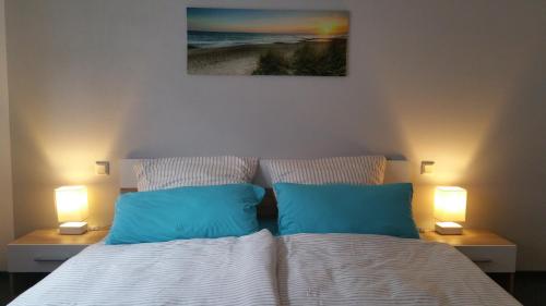 - un lit avec 2 oreillers bleus dans une chambre dans l'établissement Ferienwohnung Auszeit, à Tholey