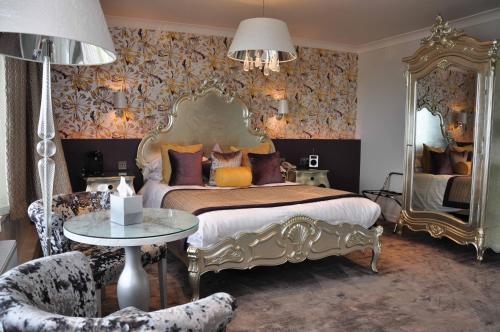 a bedroom with a bed and a mirror and a chair at Banff Springs Hotel in Banff