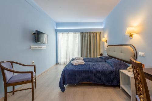a hotel room with a bed and a chair at Queen Olga Hotel in Thessaloniki