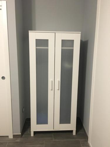 a white cabinet with two mirrors in a room at Casa di Ema in Sanremo