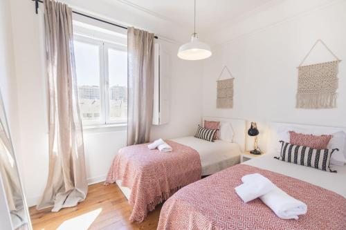 リスボンにあるLovelyStay - Bonsai Light and Comfort flatのベッドルーム1室(ベッド2台、窓付)