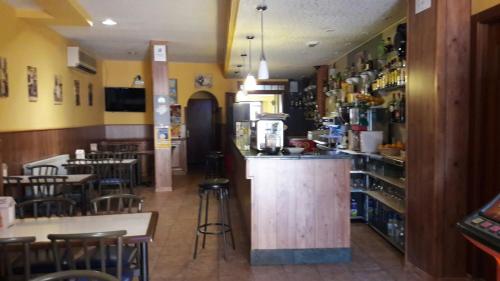 restauracja z barem oraz kilkoma stołami i krzesłami w obiekcie La Gallega w mieście Cacabelos