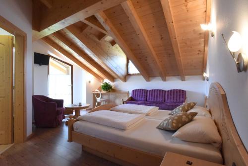 a bedroom with a bed and a wooden ceiling at Agritur Maso Chemela in Cavalese
