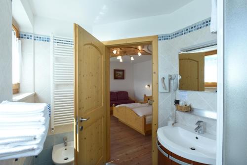 łazienka z umywalką, toaletą i łóżkiem w obiekcie Agritur Maso Chemela w Calavese